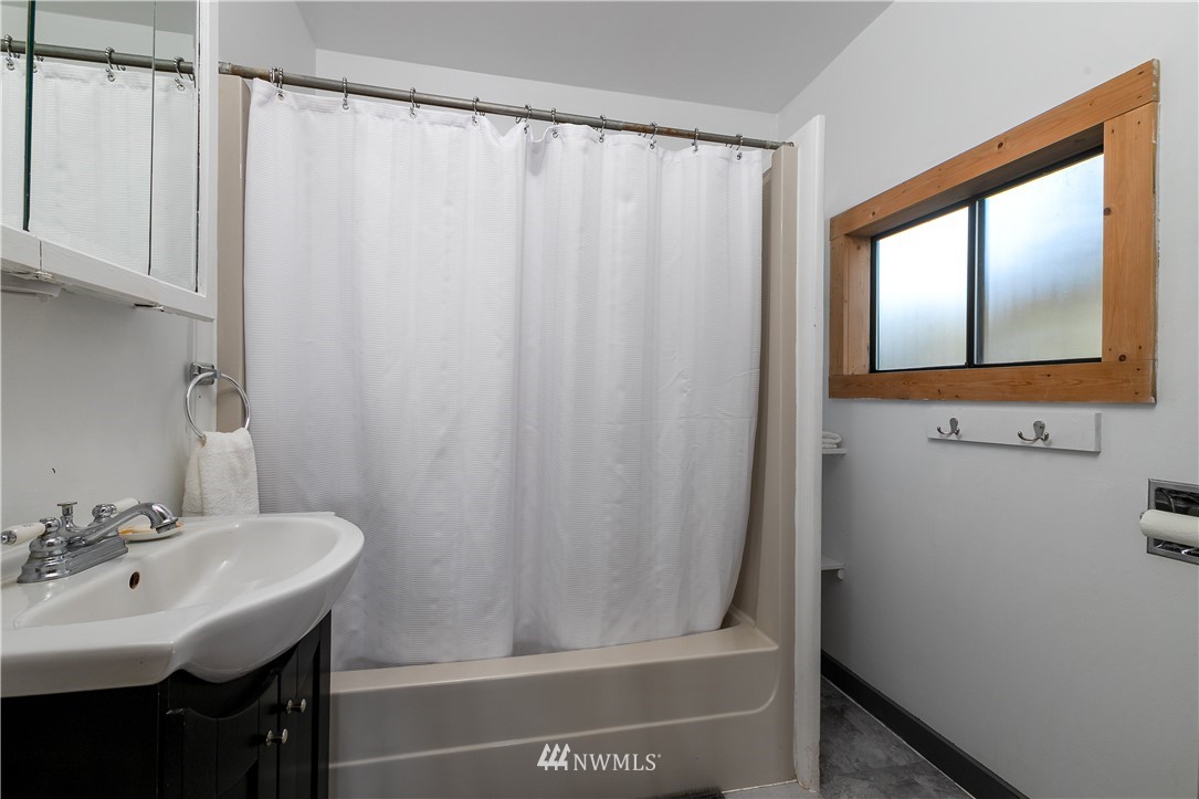 13909 Southwest Pohl Road Vashon, WA 98070 - Photo 12 of 24 a bathroom with a sink a mirror and a shower curtain