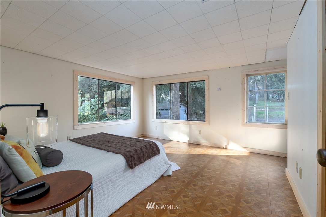 13909 Southwest Pohl Road Vashon, WA 98070 - Photo 15 of 24 a spacious bedroom with a bed and wooden floor