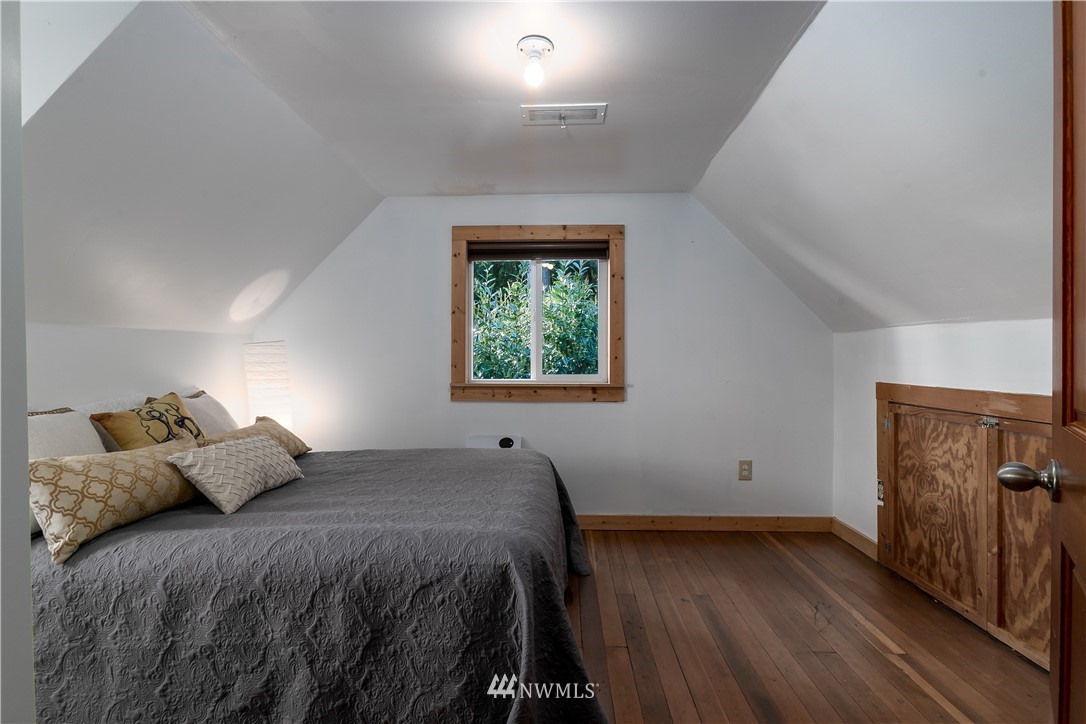 13909 Southwest Pohl Road Vashon, WA 98070 - Photo 18 of 24 a bed sitting in a bedroom next to a window
