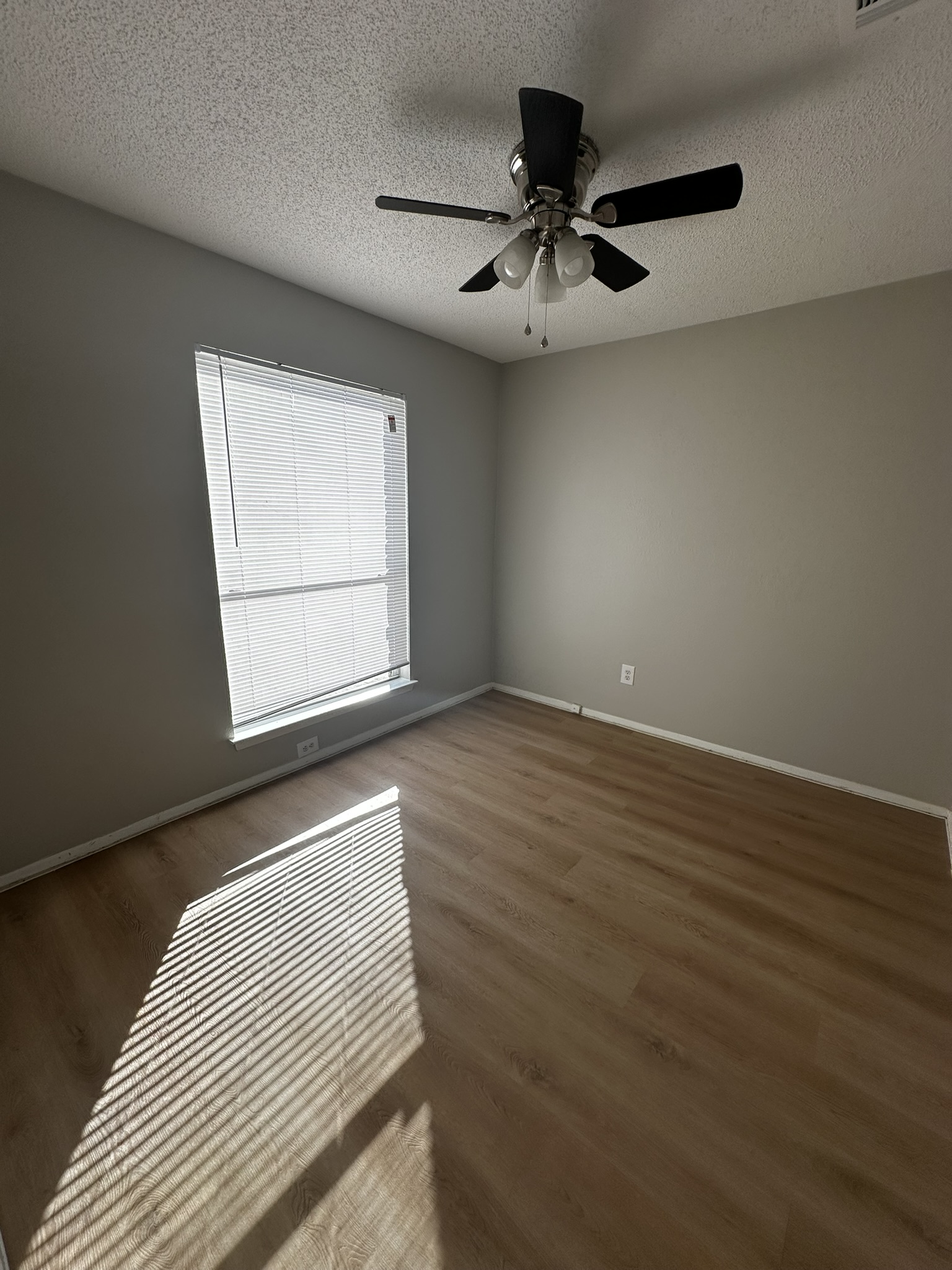 2606 Howellwood Way, Unit A Austin, TX 78748 - Photo 11 of 15 Spare room featuring a textured ceiling, wood finished floors, and ceiling fan