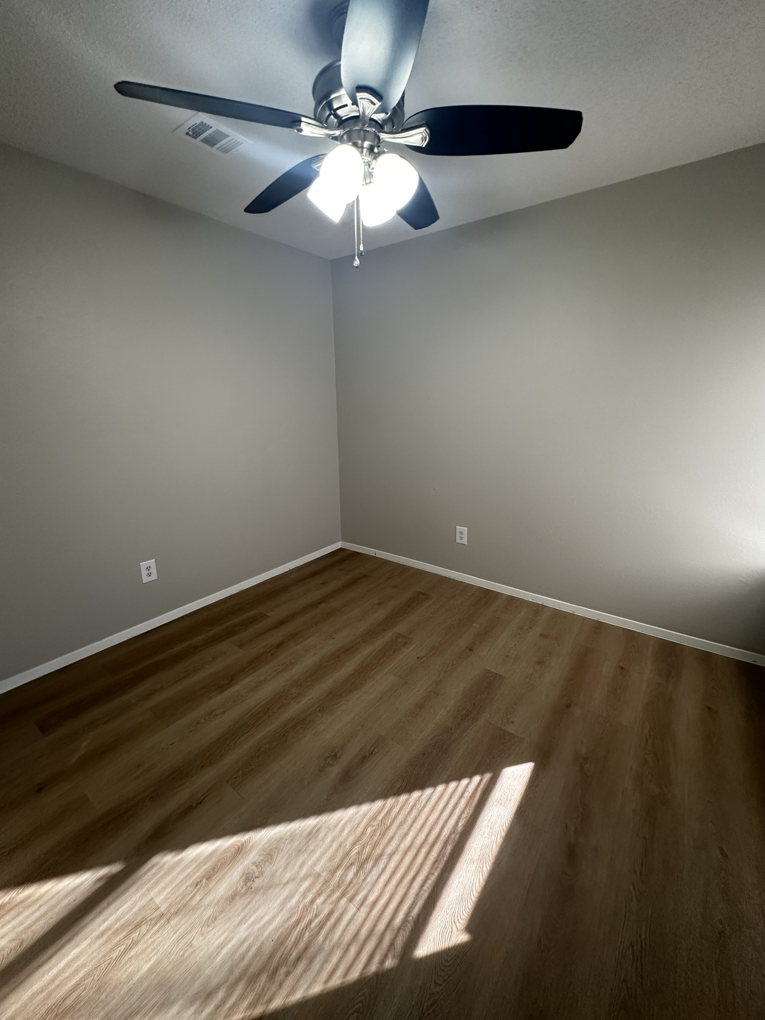 2606 Howellwood Way, Unit A Austin, TX 78748 - Photo 12 of 15 Empty room featuring dark wood-type flooring, a textured ceiling, and ceiling fan