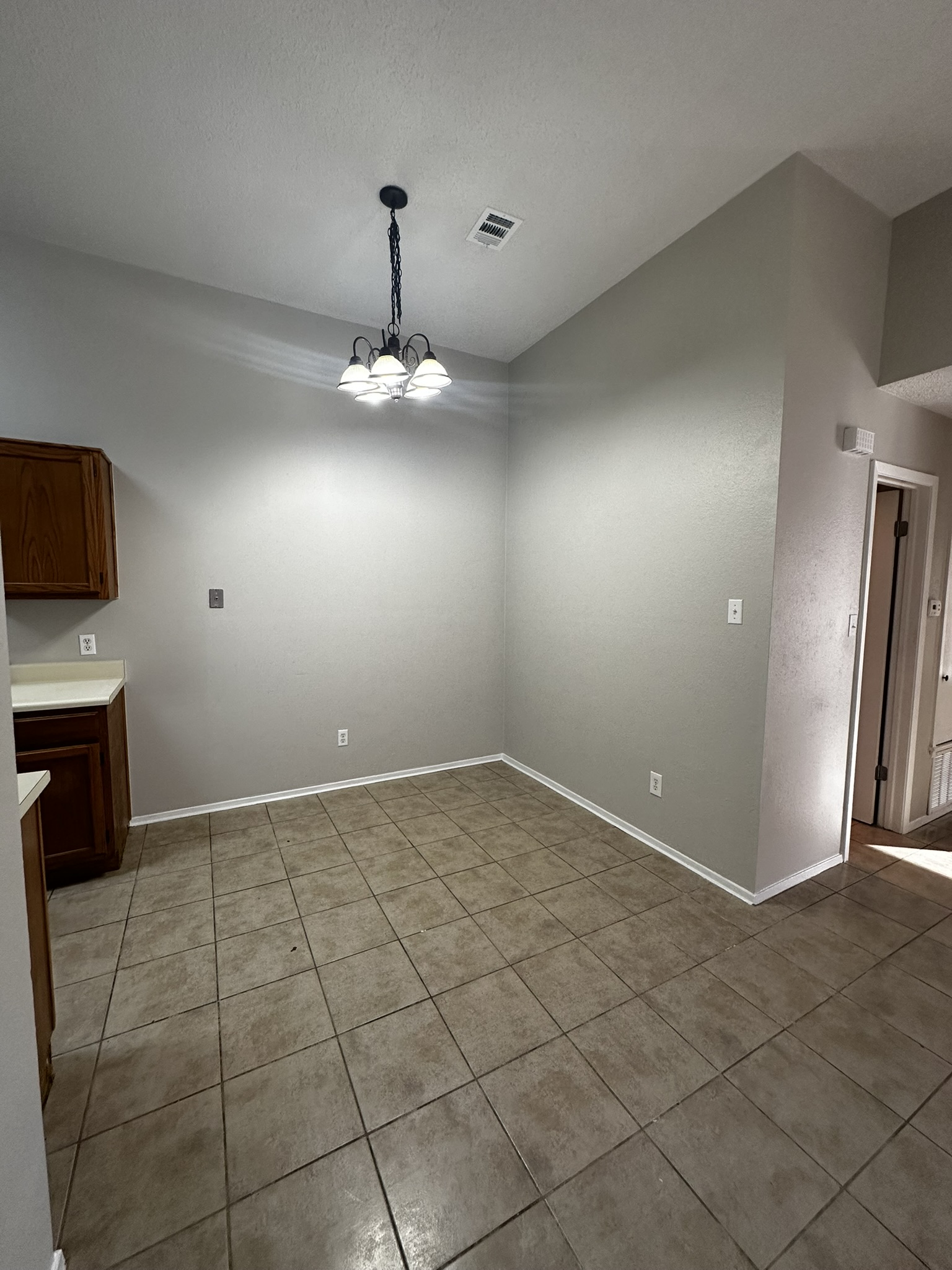 2606 Howellwood Way, Unit A Austin, TX 78748 - Photo 7 of 15 Unfurnished dining area featuring a chandelier and light tile patterned flooring
