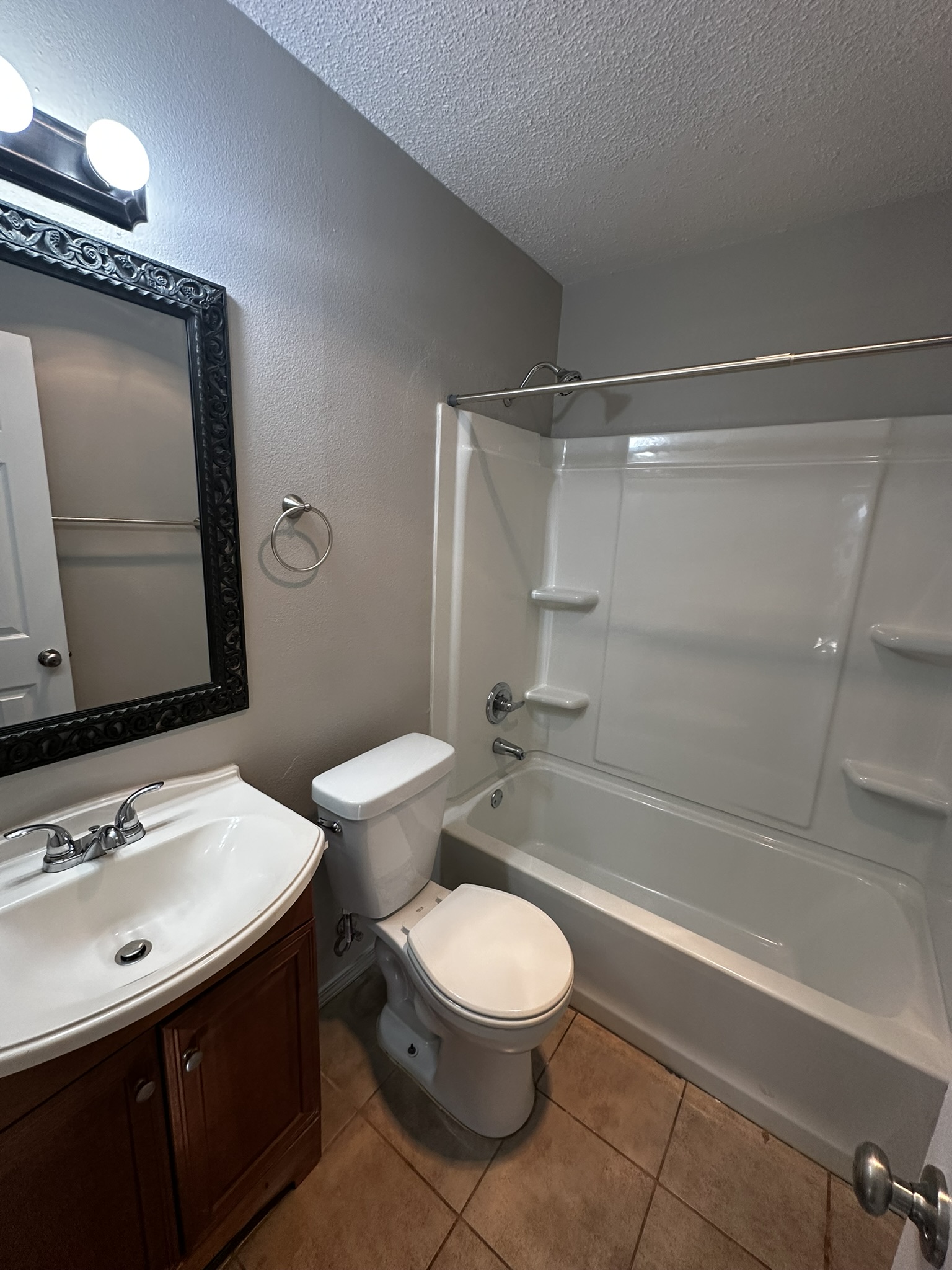 2606 Howellwood Way, Unit A Austin, TX 78748 - Photo 10 of 15 Full bath with vanity, shower / bath combination, a textured ceiling, and light tile patterned floors