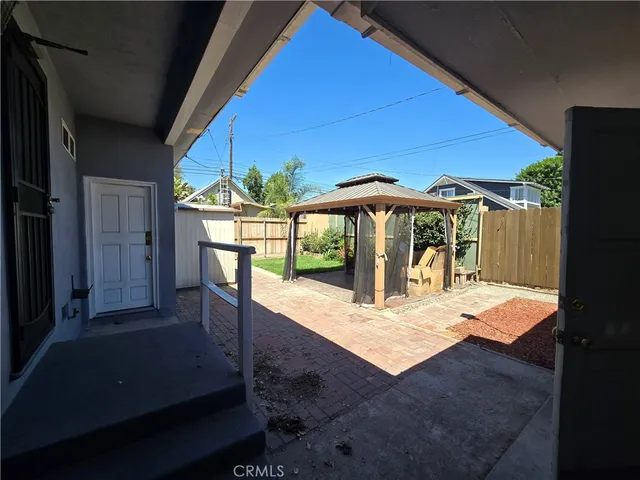 a patio with a table and chairs under an umbrella