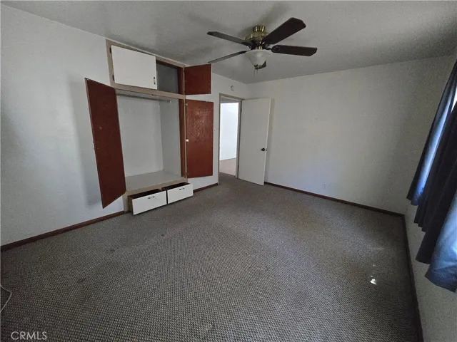 a view of a livingroom with a ceiling fan and window