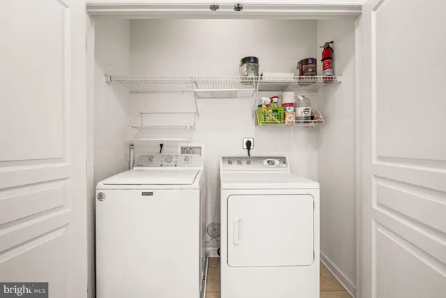 an empty room with wooden floor and kitchen view
