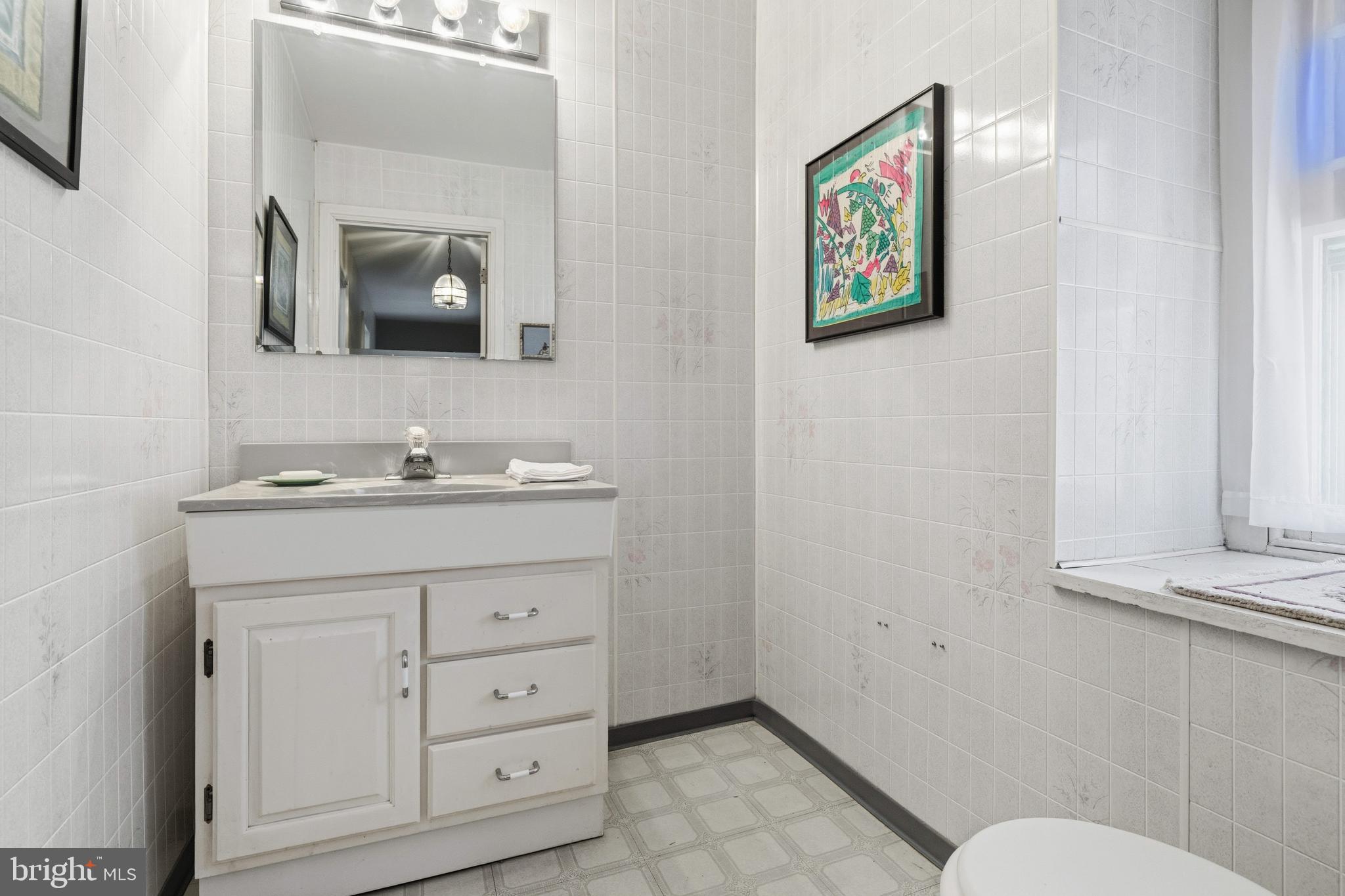 1268 Ashbourne Road Elkins Park, PA 19027 - Photo 28 of 46 a bathroom with a toilet sink and mirror