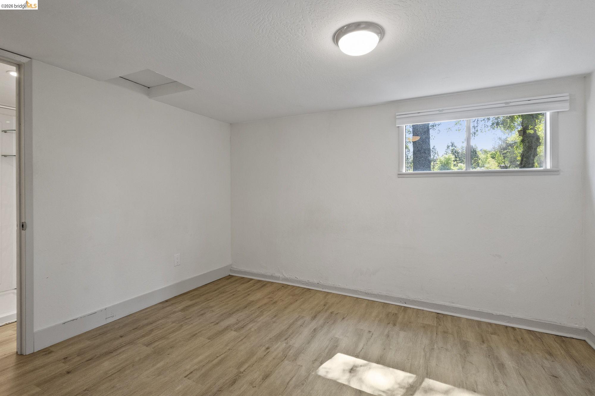 18363 Yosemite Road Tuolumne, CA 95379 - Photo 25 of 34 Room featuring light wood-finish flooring, white painted walls, and a recessed window