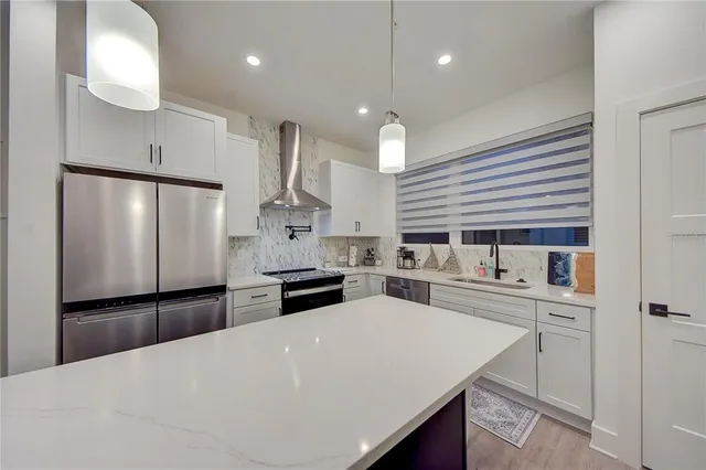 a kitchen with a sink dishwasher stove and white cabinets