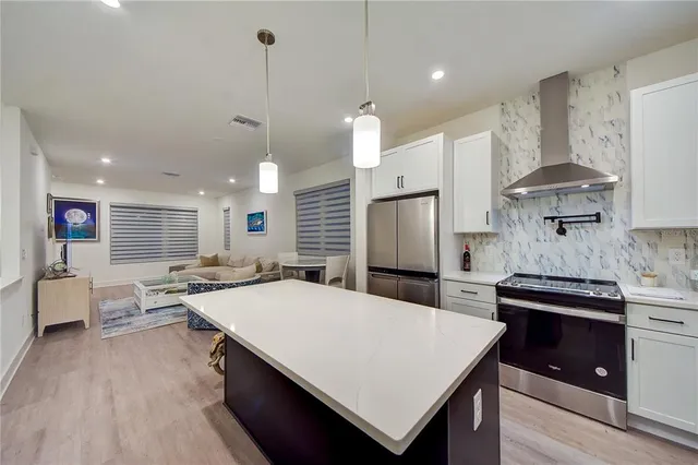 a large kitchen with kitchen island a island a stove a sink a refrigerator and a fireplace