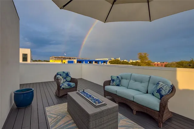 an outdoor sitting area with furniture and umbrella
