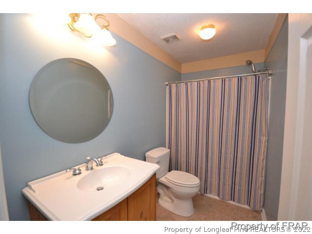 511 Berwick Drive Raeford, NC 28376 - Photo 14 of 26 a bathroom with a sink mirror and toilet