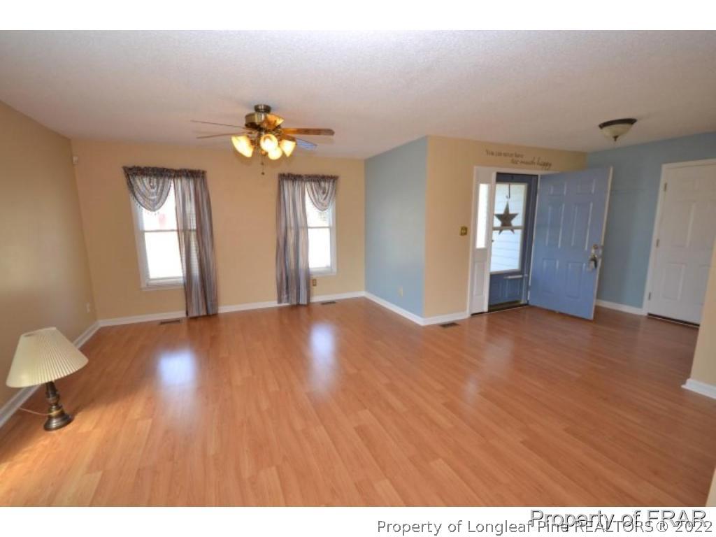 511 Berwick Drive Raeford, NC 28376 - Photo 2 of 26 a view of an empty room with window and wooden floor