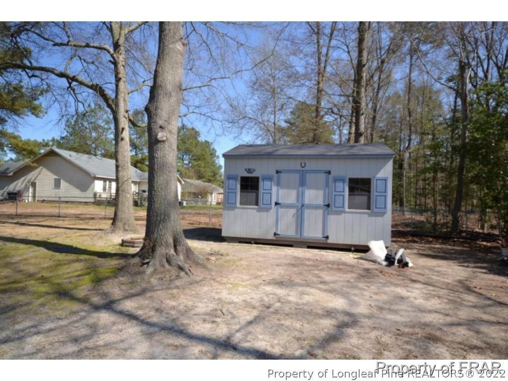 511 Berwick Drive Raeford, NC 28376 - Photo 23 of 26 a view of a house with backyard and a tree
