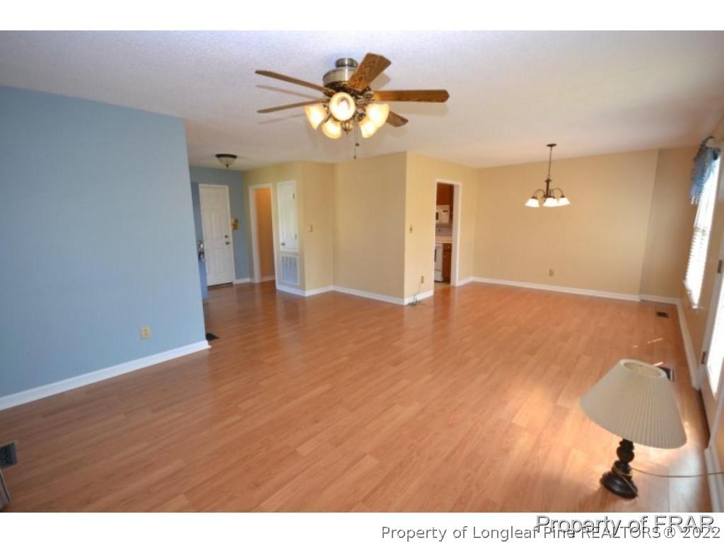 511 Berwick Drive Raeford, NC 28376 - Photo 5 of 26 a view of a livingroom with a chandelier fan and wooden floor