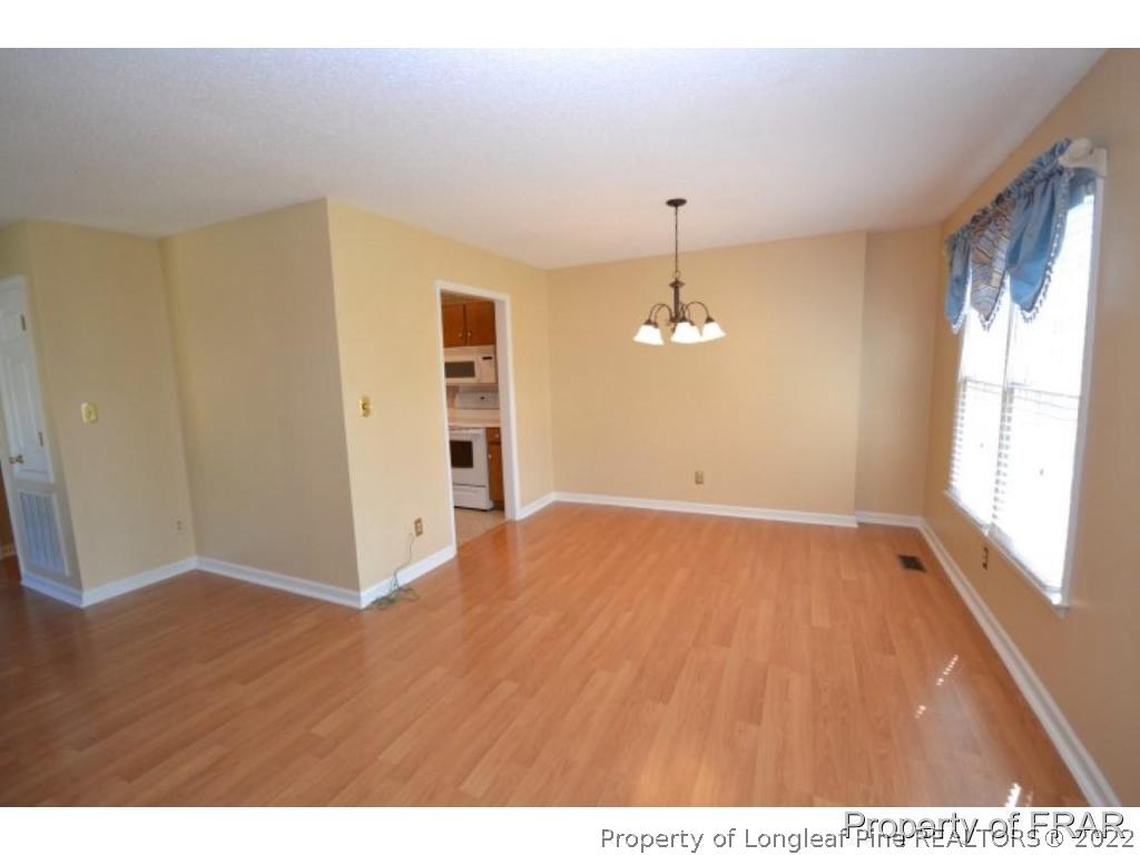 511 Berwick Drive Raeford, NC 28376 - Photo 6 of 26 a view of empty room with wooden floor and fan