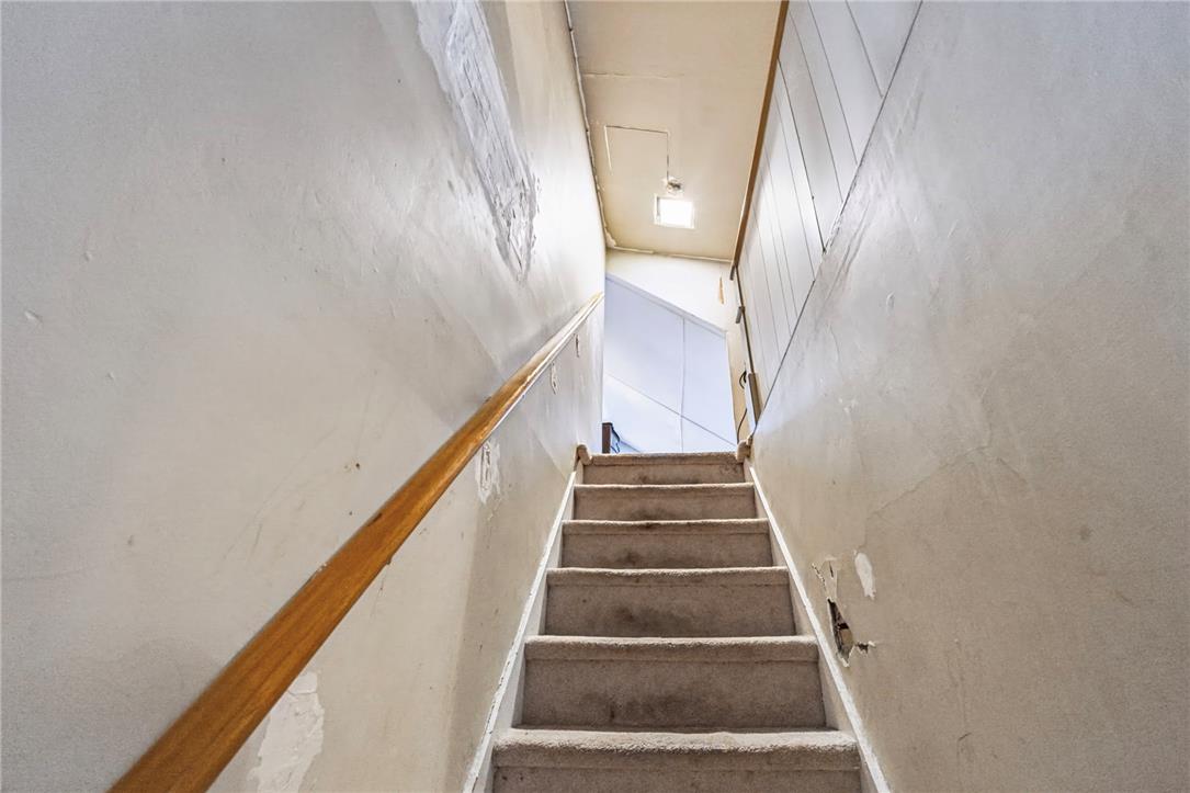 1030 Monocacy Street Bethlehem, PA 18018 - Photo 22 of 34 An enclosed carpeted staircase features a simple wooden handrail leading to the upper level.