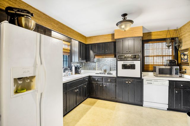 a kitchen with stainless steel appliances granite countertop a sink a stove and a refrigerator