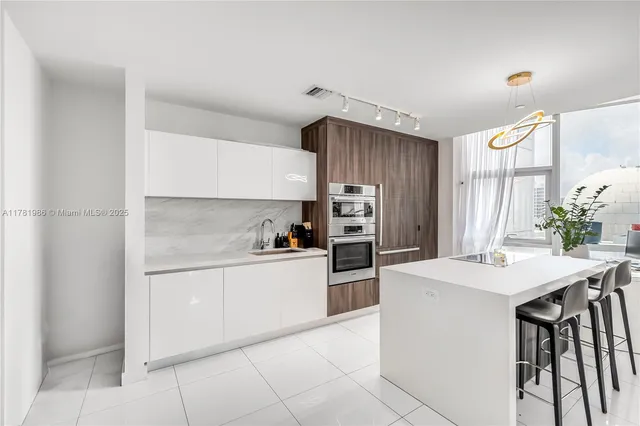 a kitchen with granite countertop a sink appliances cabinets and counter space
