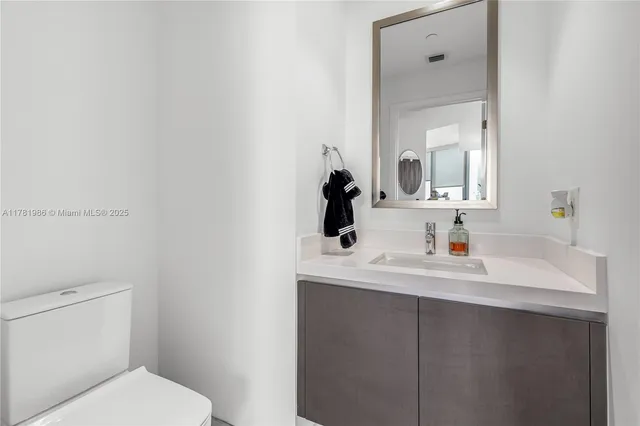 a bathroom with a sink a toilet and mirror