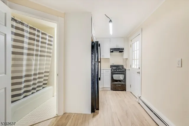 a view of kitchen with refrigerator and window