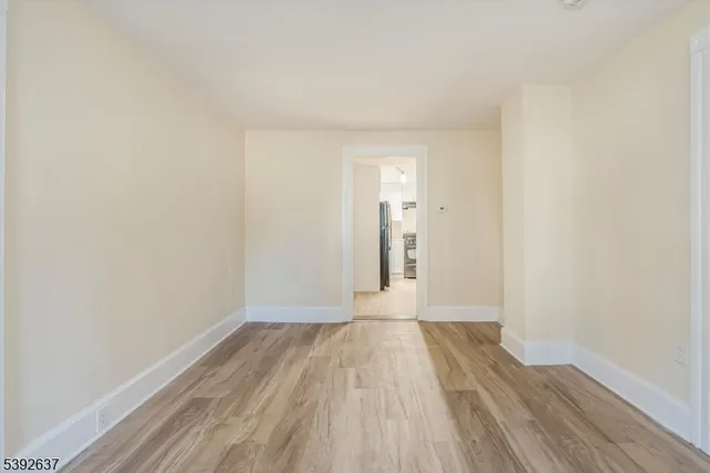 a view of a room with wooden floor and white walls