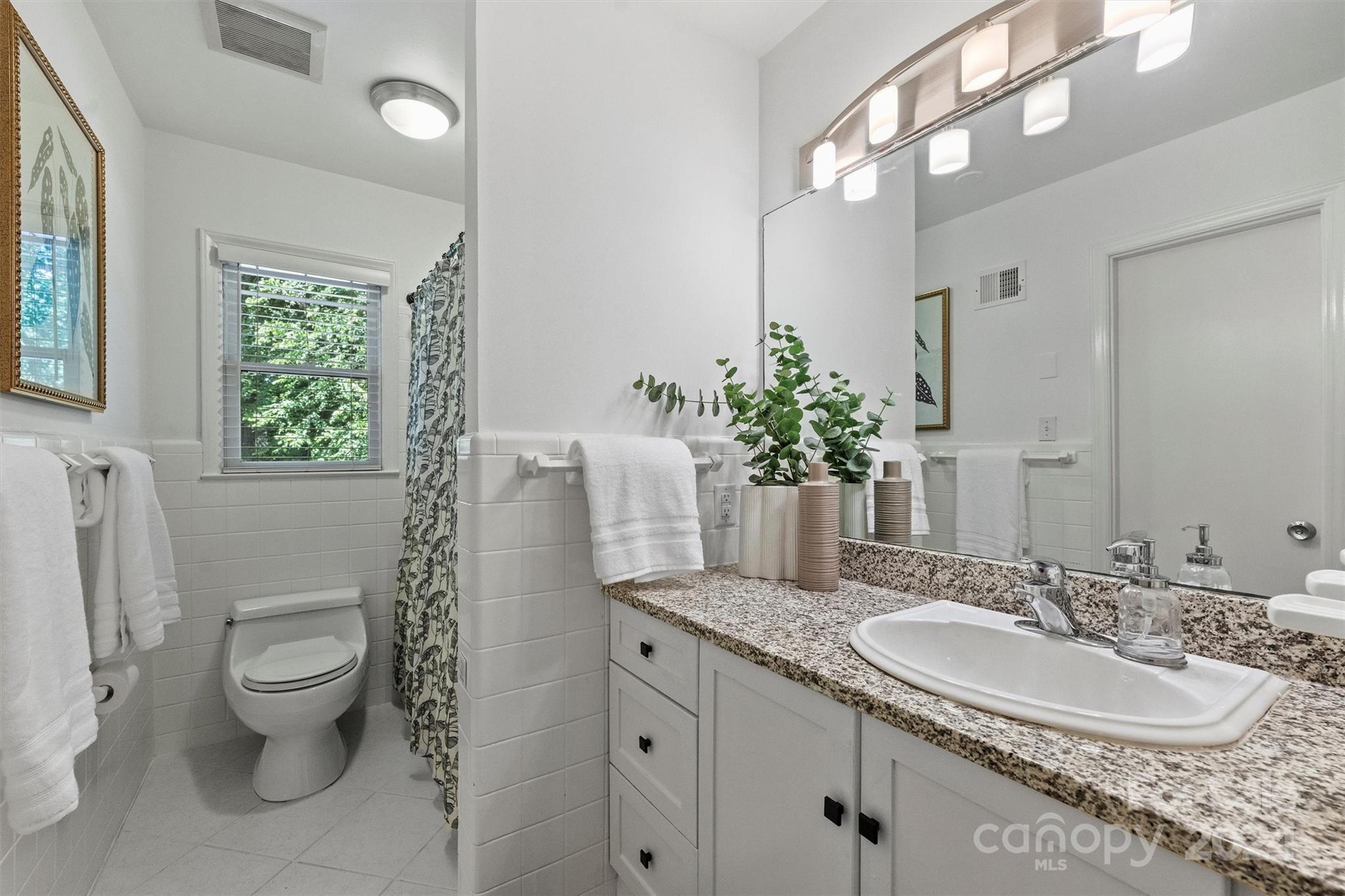 6810 Folger Drive Charlotte, NC 28270 - Photo 32 of 47 a bathroom with a granite countertop sink a toilet and a mirror