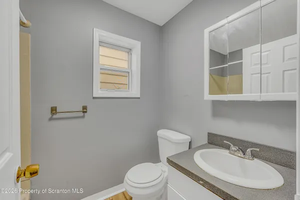 a bathroom with a sink a toilet and mirror