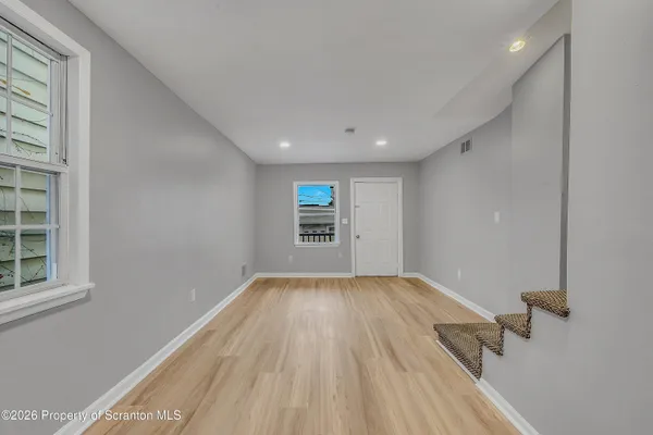 wooden floor in an empty room with a window