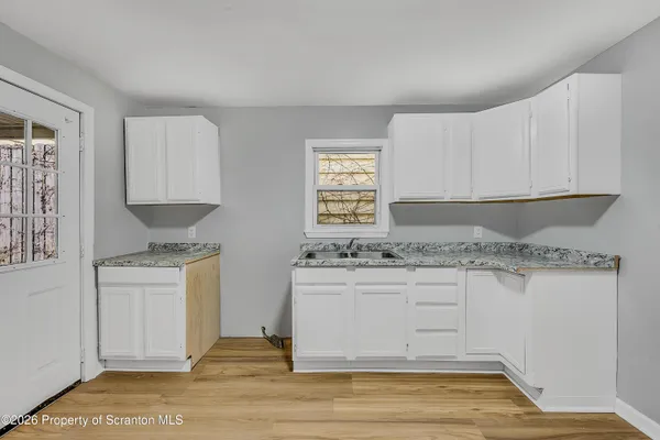 a kitchen with granite countertop a stove a sink and a microwave