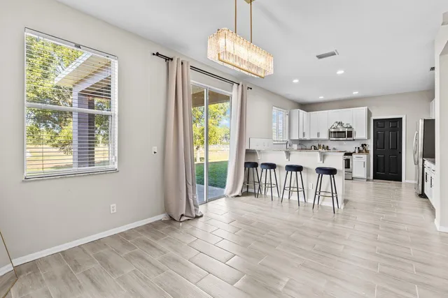 a view of a kitchen with dining space wooden floor and windows