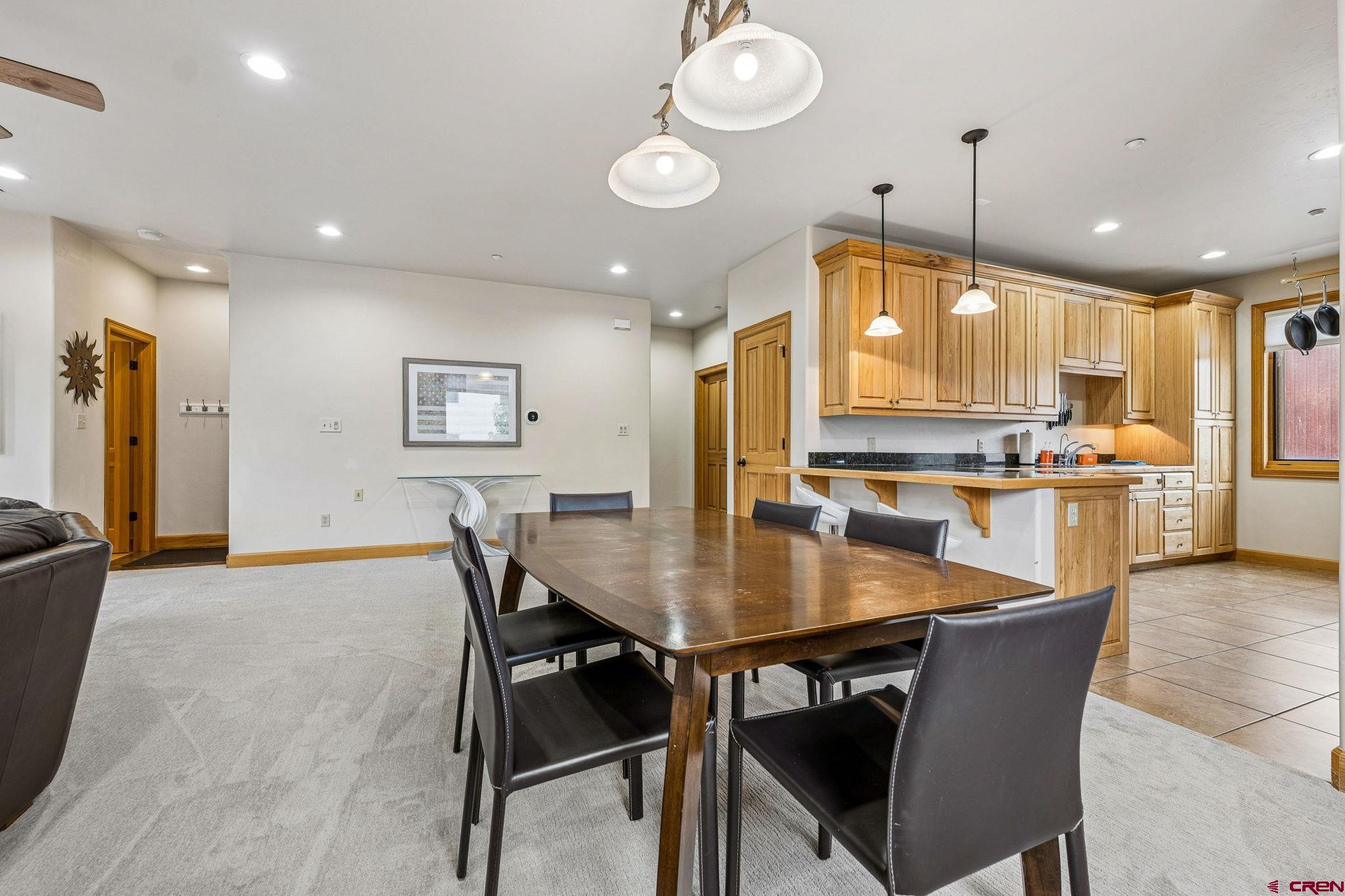 1422 Animas View Drive, Unit 55 Durango, CO 81301 - Photo 8 of 44 an open kitchen with granite countertop a stove a sink a dining table and chairs
