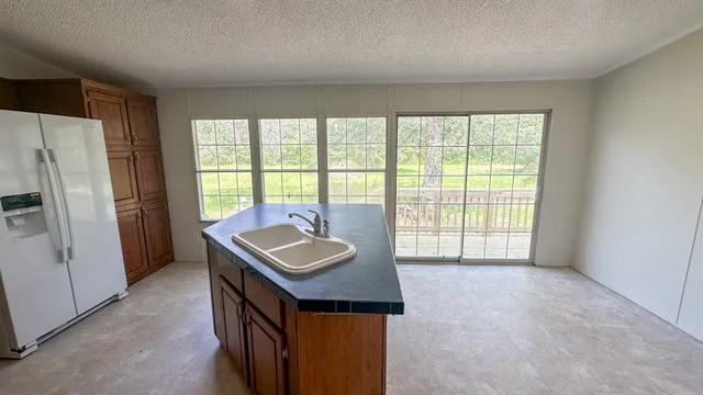 a kitchen with kitchen island granite countertop a sink a stove and a refrigerator