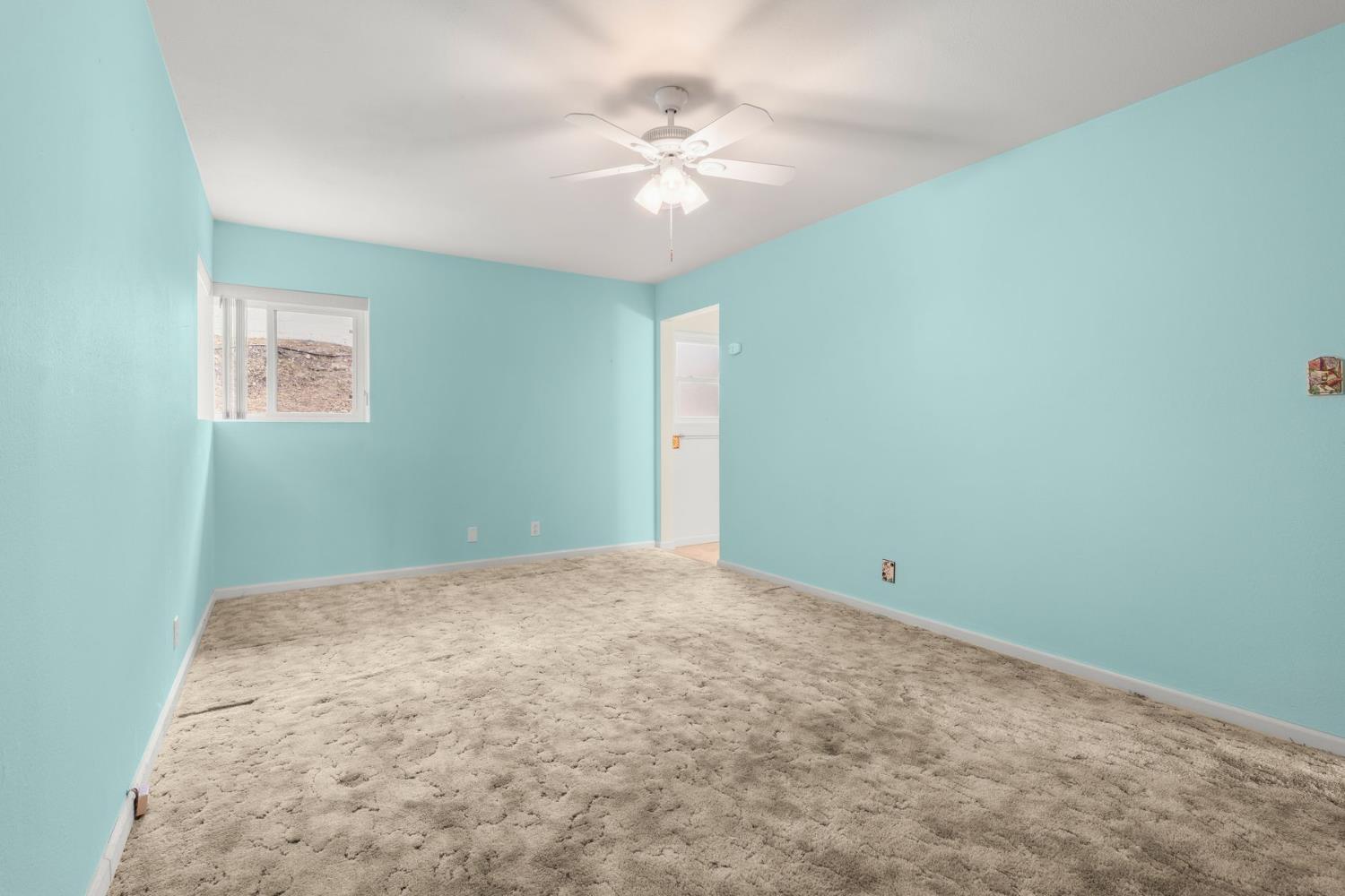 25 Hill Street Oak View, CA 93022 - Photo 11 of 16 an empty room with a chandelier fan and windows