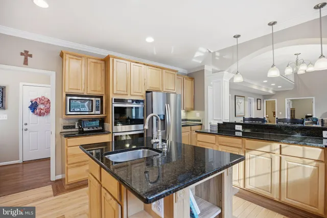 a kitchen with stainless steel appliances granite countertop a sink a stove and a refrigerator