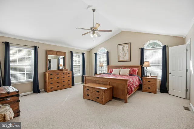 a spacious bedroom with a bed and wooden floor