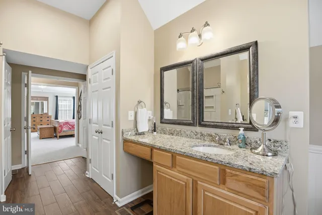 a en suite bathroom with a granite countertop sink and a mirror