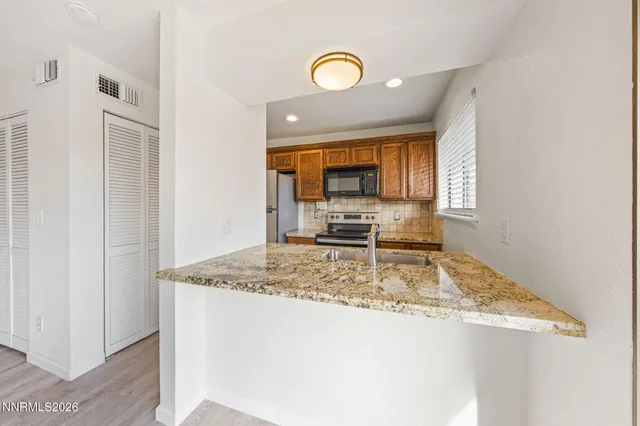 a kitchen with stainless steel appliances granite countertop a stove a sink and a refrigerator