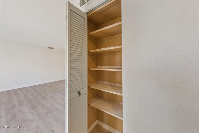 an empty room with wooden floor and window