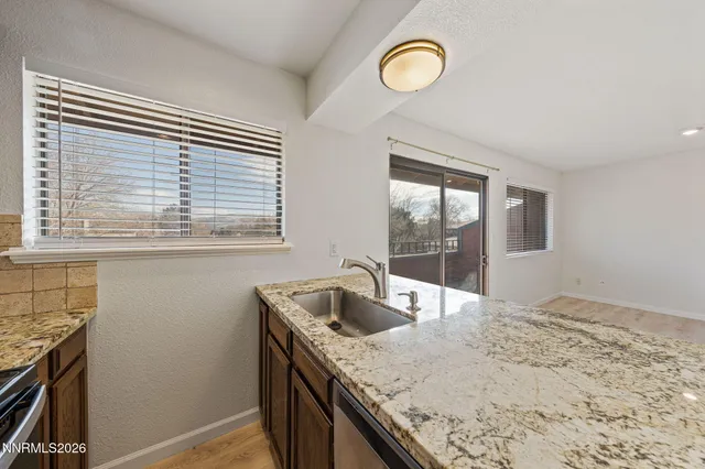a bathroom with a granite countertop sink a toilet and shower