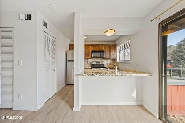 a kitchen with a granite countertop sink and refrigerator