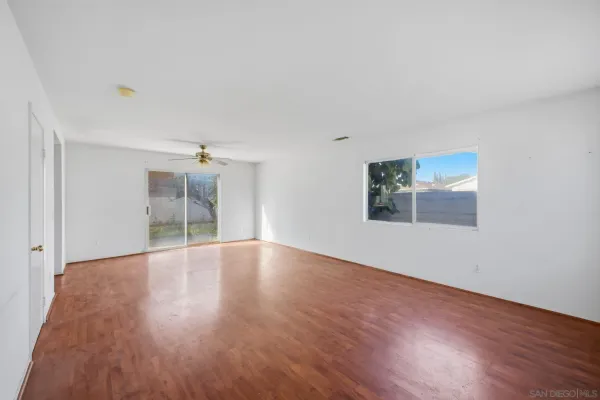a big room with wooden floor and windows