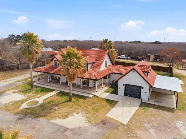 an aerial view of a house with swimming pool and mountains