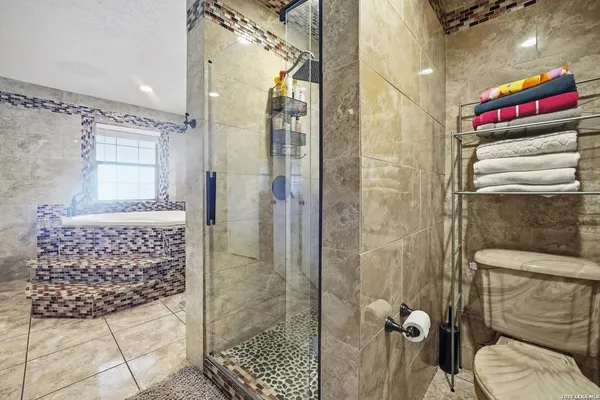 a bathroom with a sink a toilet and shower