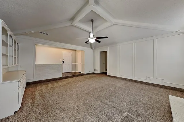 a view of a livingroom with a ceiling fan and window