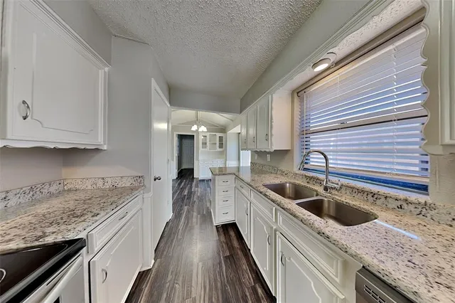 a kitchen with granite countertop a sink and cabinets