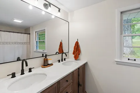 a bathroom with double vanity sink and a window