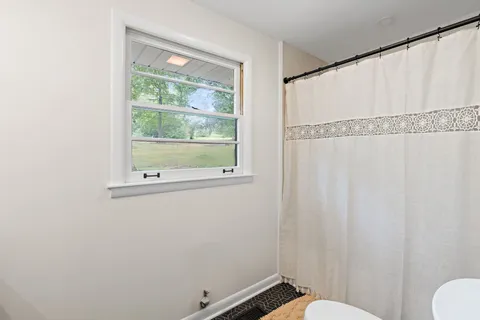 a bathroom with a window and a shower
