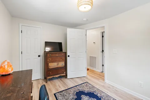 a bedroom with a bed and wooden floor