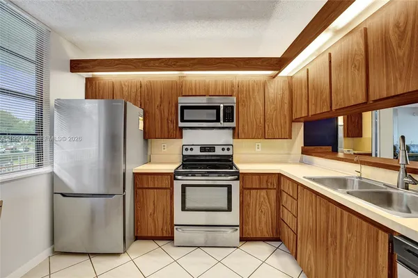 a kitchen with a refrigerator and a stove top oven